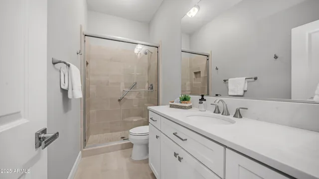 a bathroom with a double vanity sink toilet mirror and shower