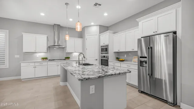 a kitchen with granite countertop a refrigerator and a stove top oven