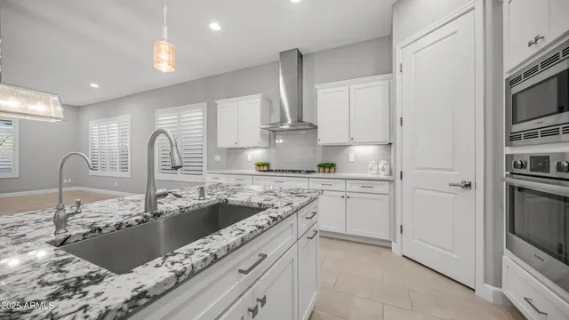 a kitchen with stainless steel appliances kitchen island granite countertop a stove and a sink