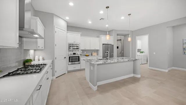 a large kitchen with white cabinets and stainless steel appliances