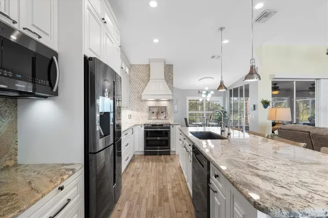a kitchen with stainless steel appliances granite countertop a stove and a sink