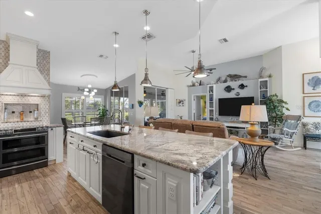 a living room with furniture a chandelier and a flat screen tv
