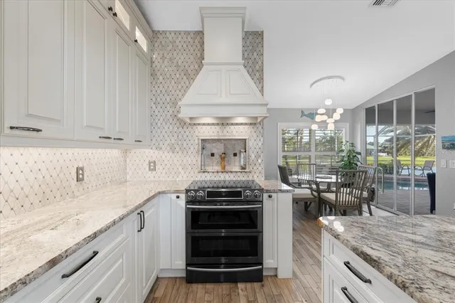 a kitchen with stainless steel appliances granite countertop a sink a oven and a refrigerator