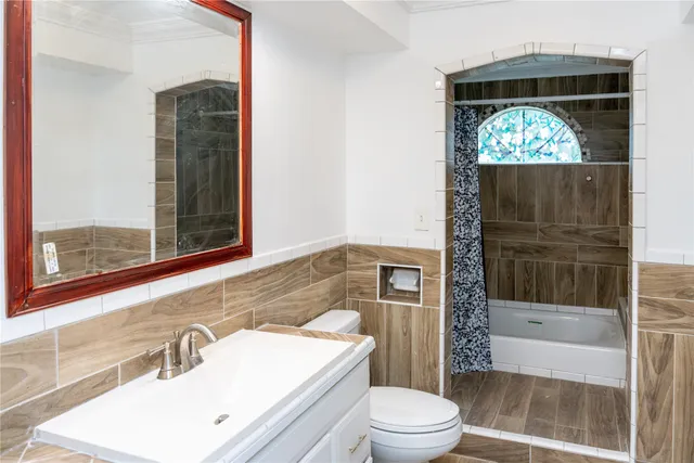 an empty room with wooden floor chandelier fan and windows