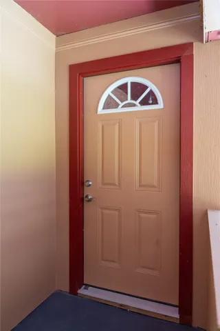 an empty room with wooden floor closet and windows
