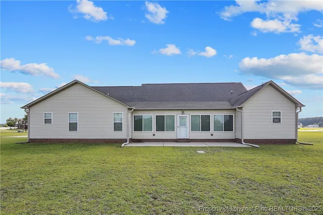 a view of a house with a yard and potted plants
