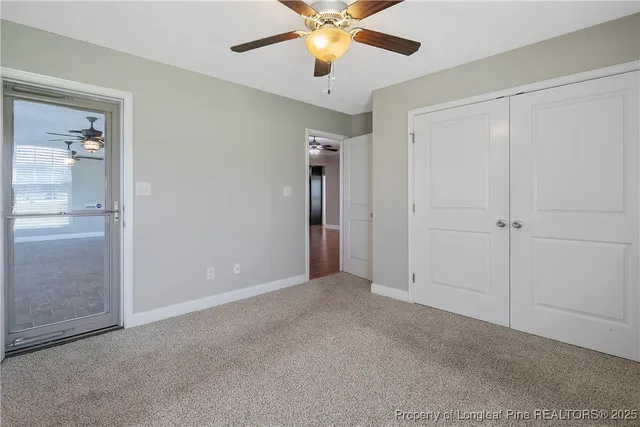 an empty room with closet and a chandelier fan