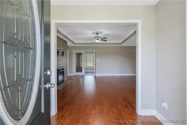 a view of a hallway with wooden floor and a livingroom view