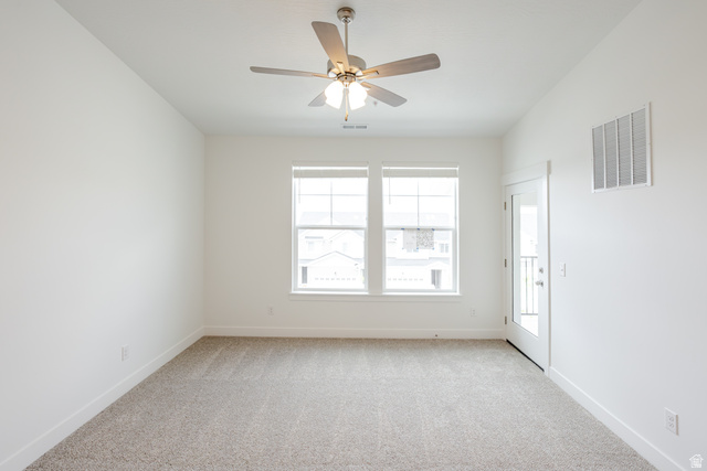 675 West 4500th South, Unit P301 Mapleton, UT 84664 - Photo 15 of 16 Spacious room featuring neutral carpeting, a modern ceiling fan with lighting, two large windows with blinds, a glass-paned door, and white baseboards