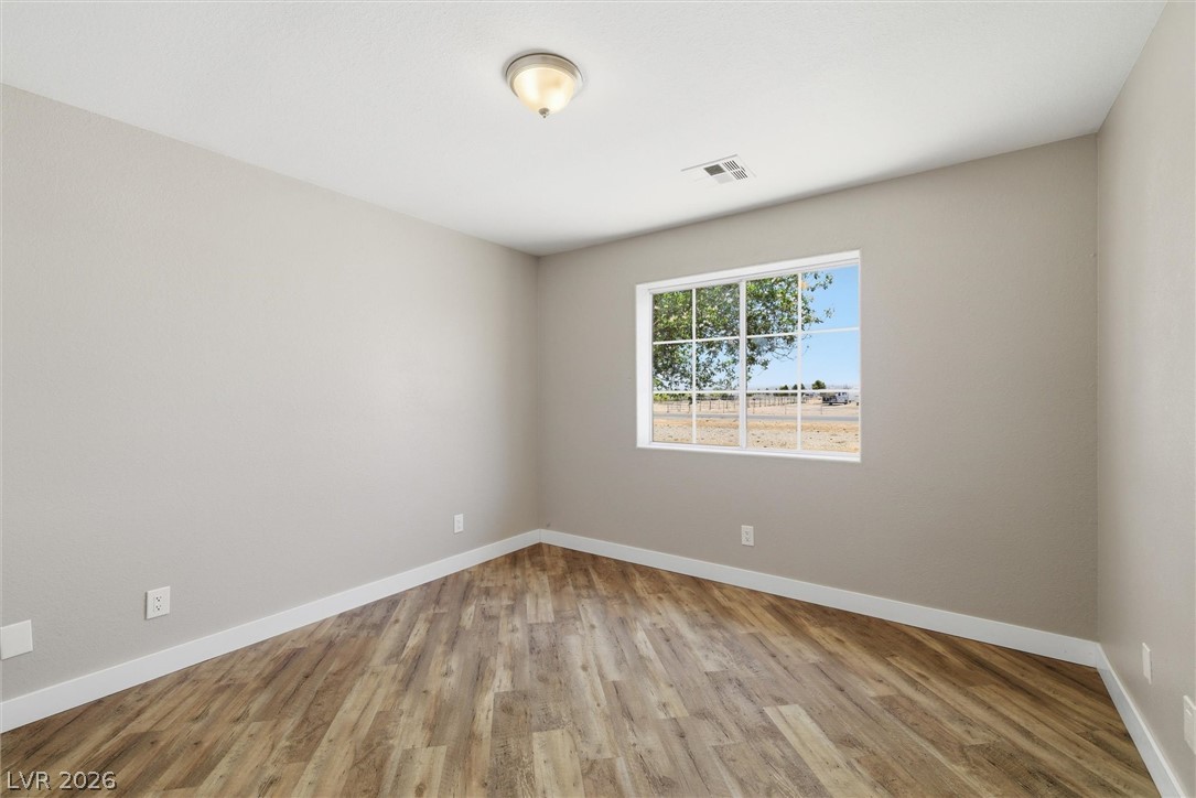 2780 West Simkins Road Pahrump, NV 89060 - Photo 28 of 40 Wood-look flooring and a bright window elevate this versatile room.