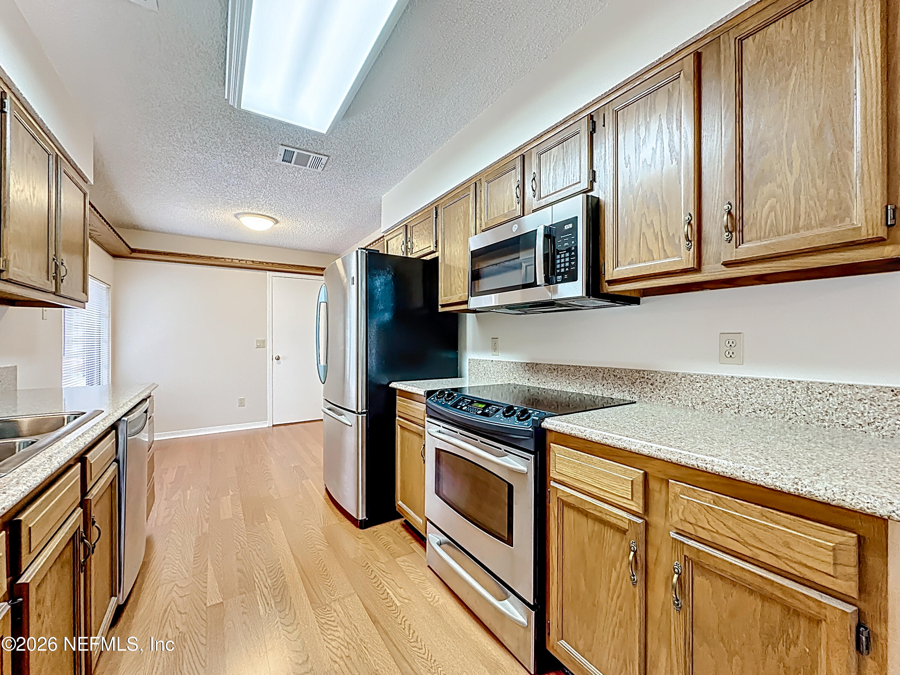 10298 Lone Star Road Jacksonville, FL 32225 - Photo 13 of 42 a kitchen with stainless steel appliances granite countertop a stove a sink and a microwave