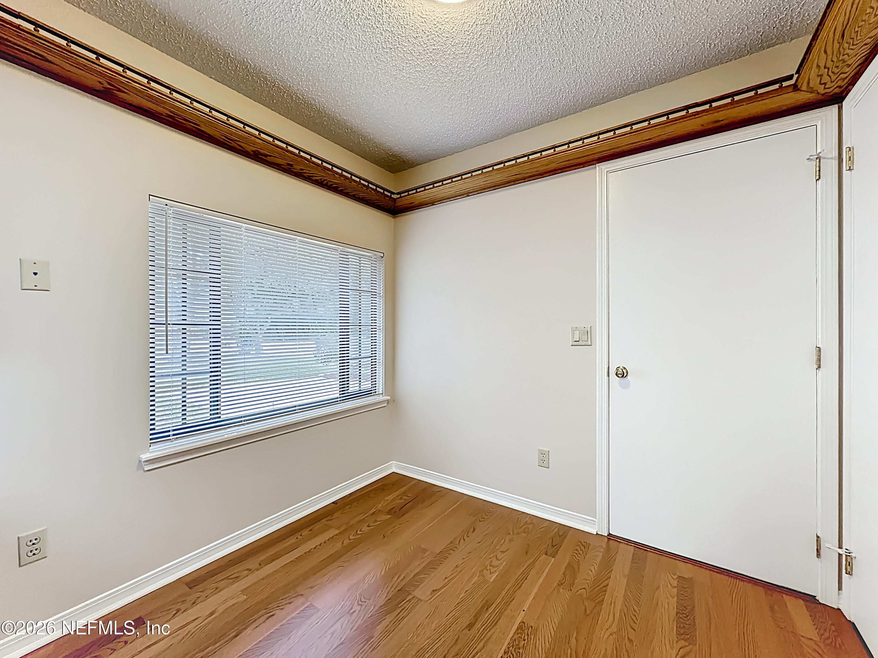 10298 Lone Star Road Jacksonville, FL 32225 - Photo 14 of 42 a view of an empty room with wooden floor and a window