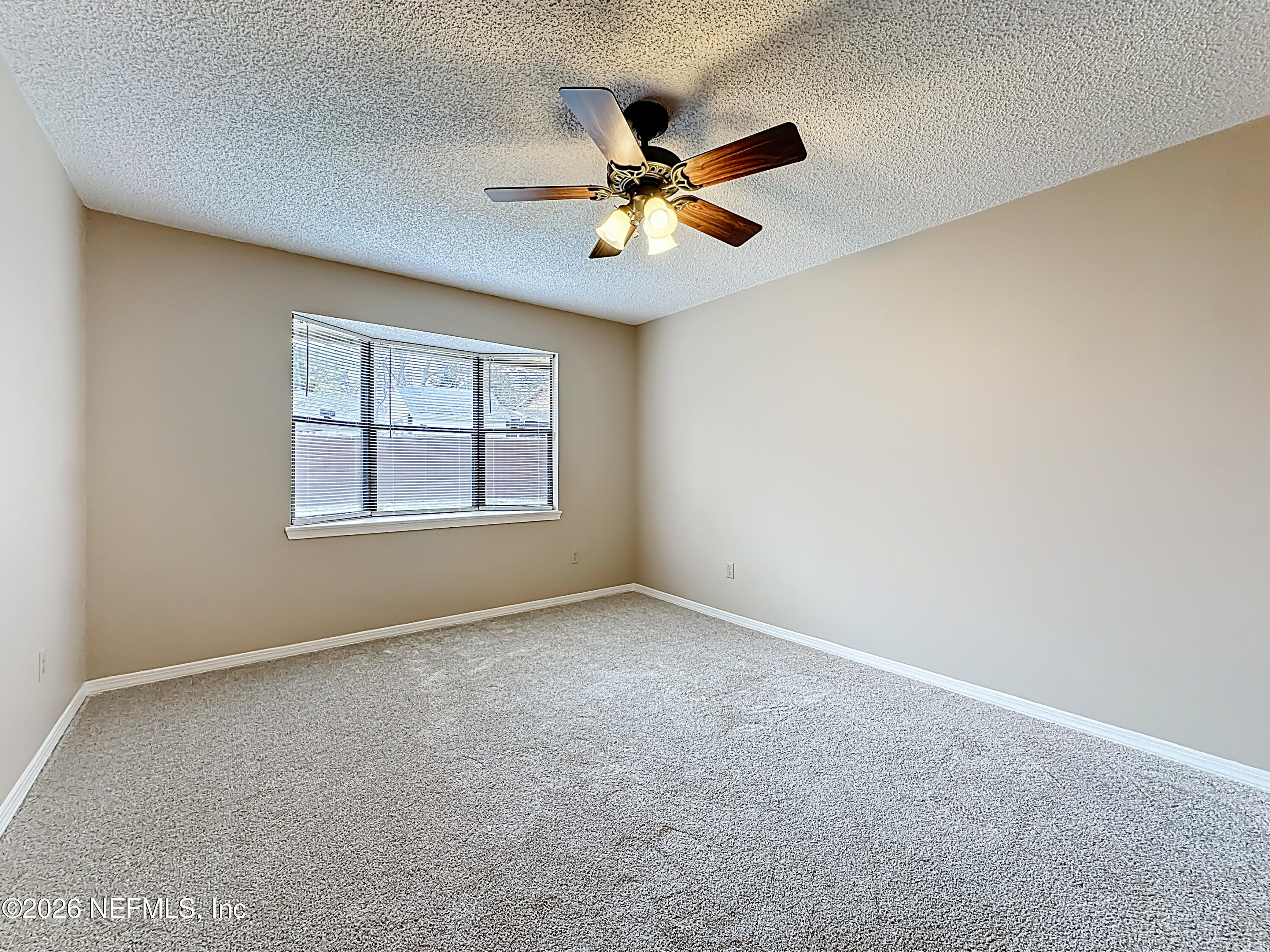 10298 Lone Star Road Jacksonville, FL 32225 - Photo 15 of 42 an empty room with windows and ceiling fan