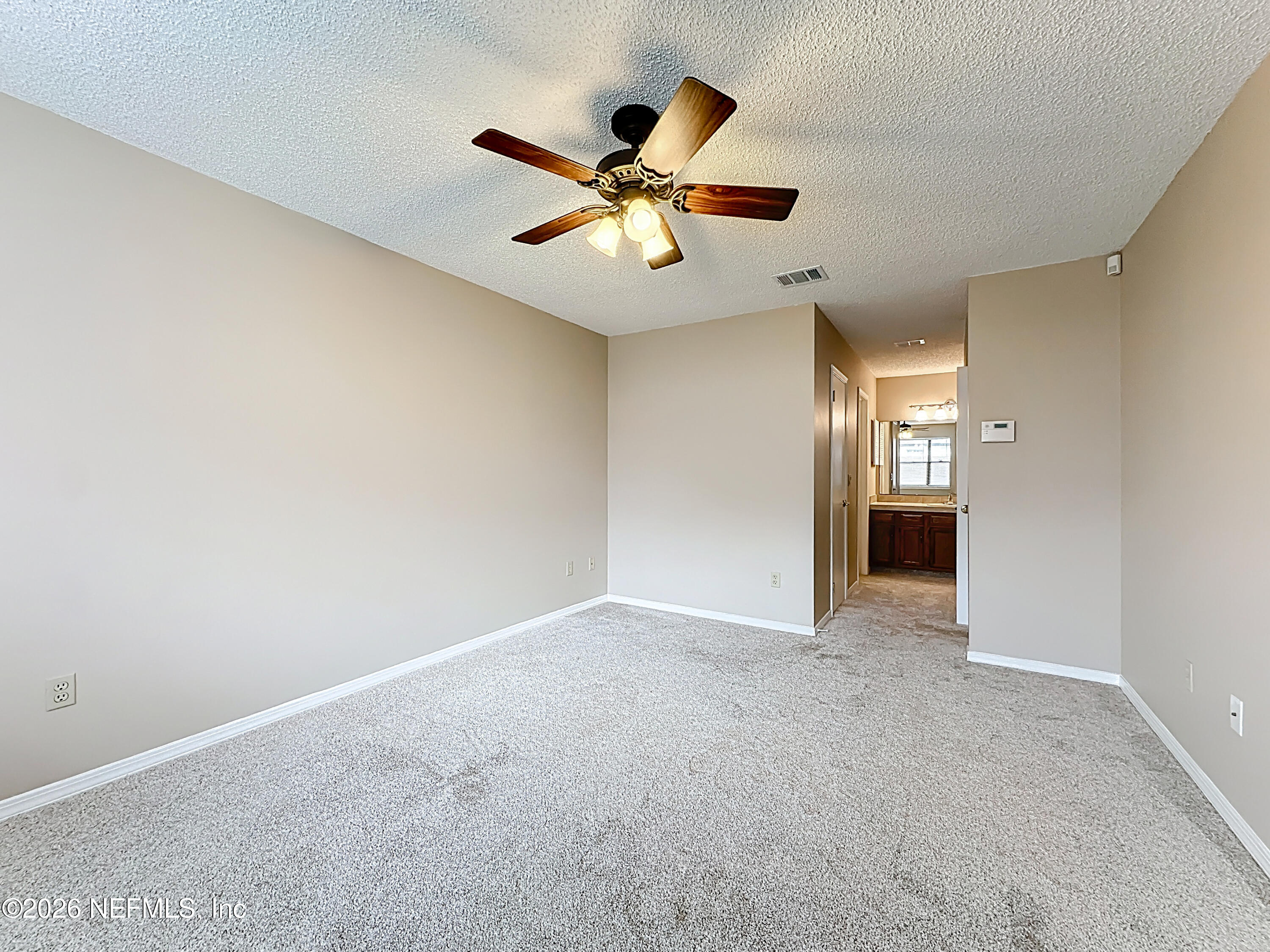 10298 Lone Star Road Jacksonville, FL 32225 - Photo 17 of 42 a view of an empty room with a ceiling fan