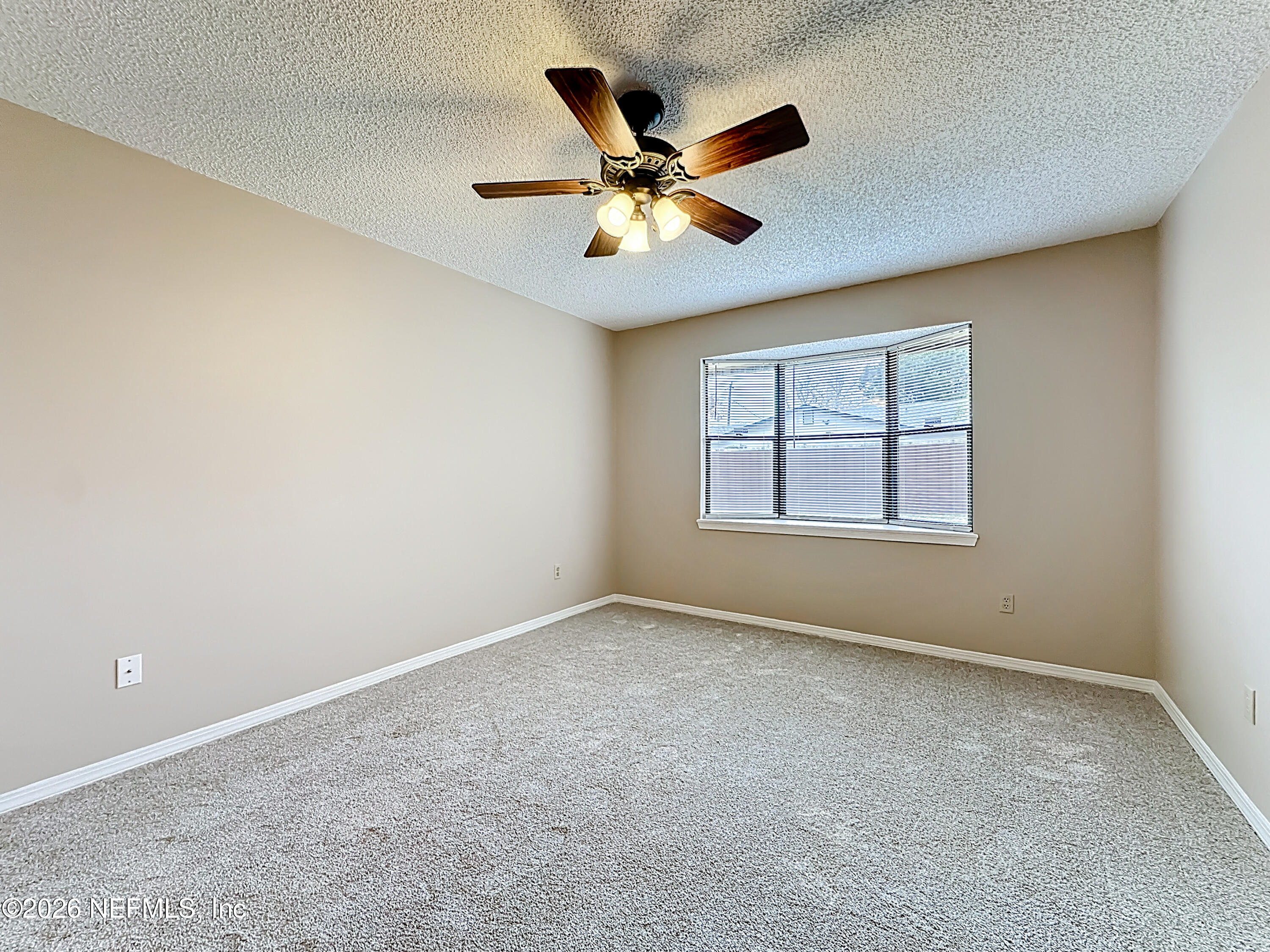 10298 Lone Star Road Jacksonville, FL 32225 - Photo 18 of 42 an empty room with ceiling fan and windows