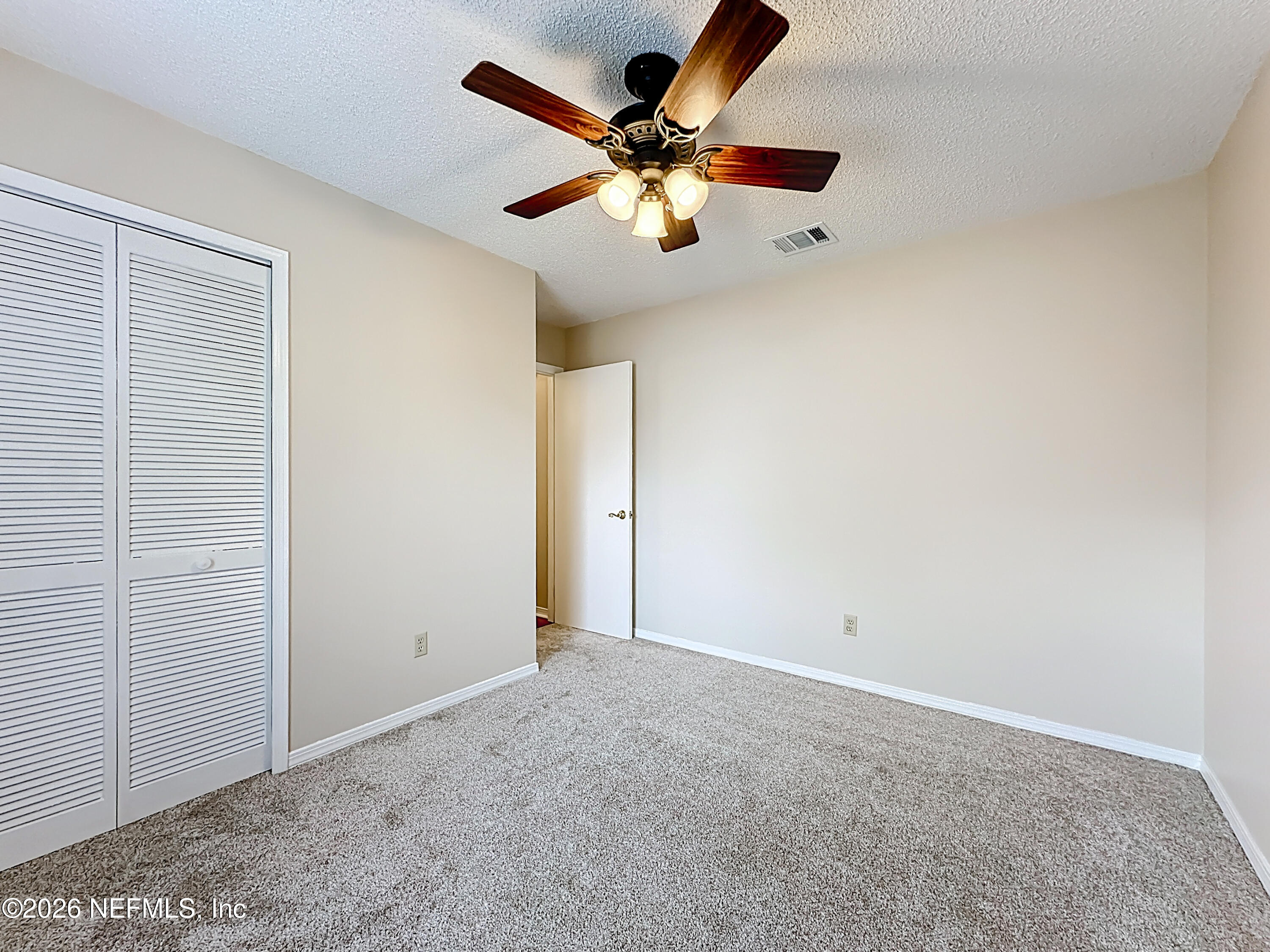 10298 Lone Star Road Jacksonville, FL 32225 - Photo 23 of 42 an empty room with windows and fan