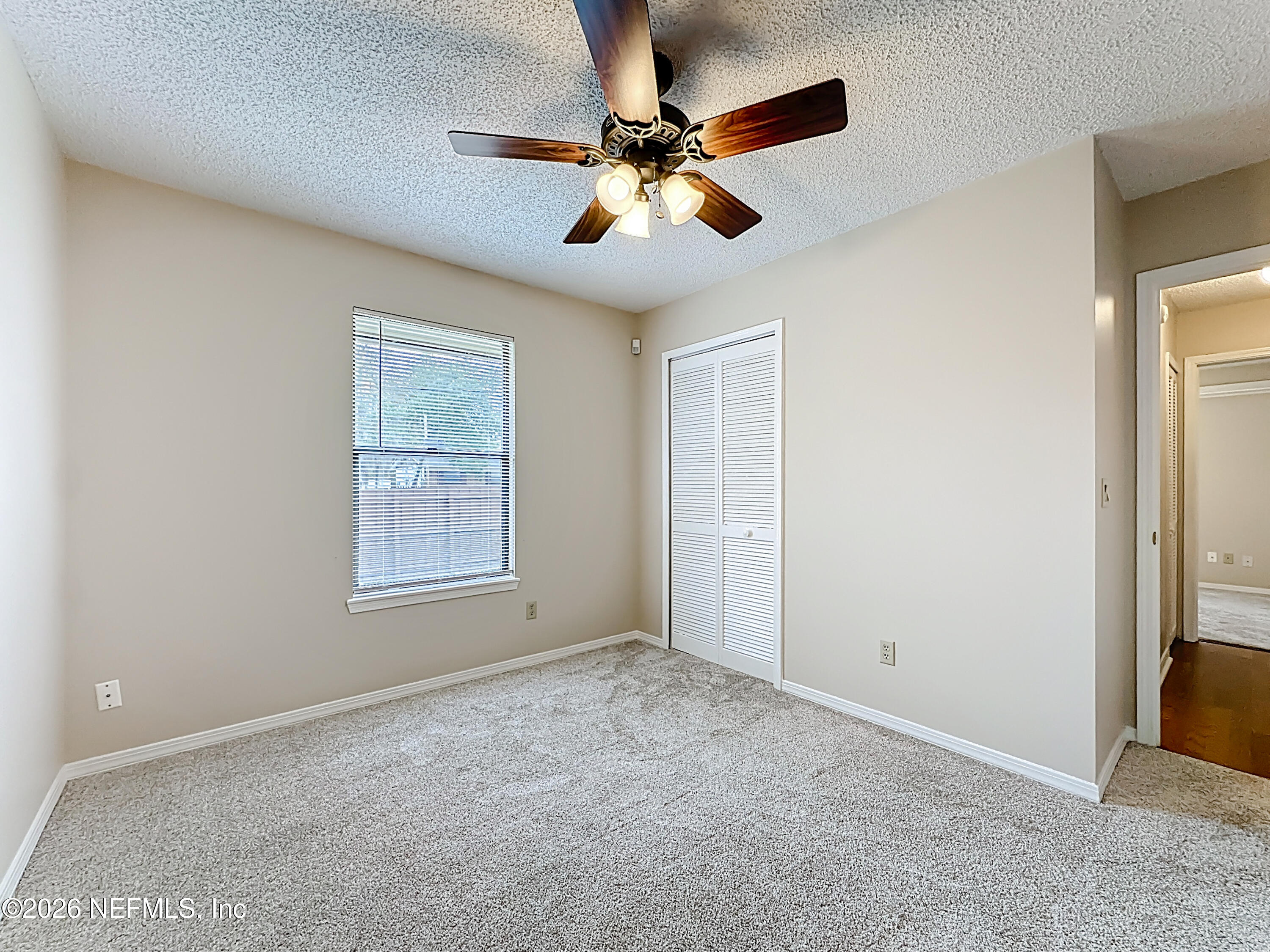 10298 Lone Star Road Jacksonville, FL 32225 - Photo 24 of 42 an empty room with windows and fan