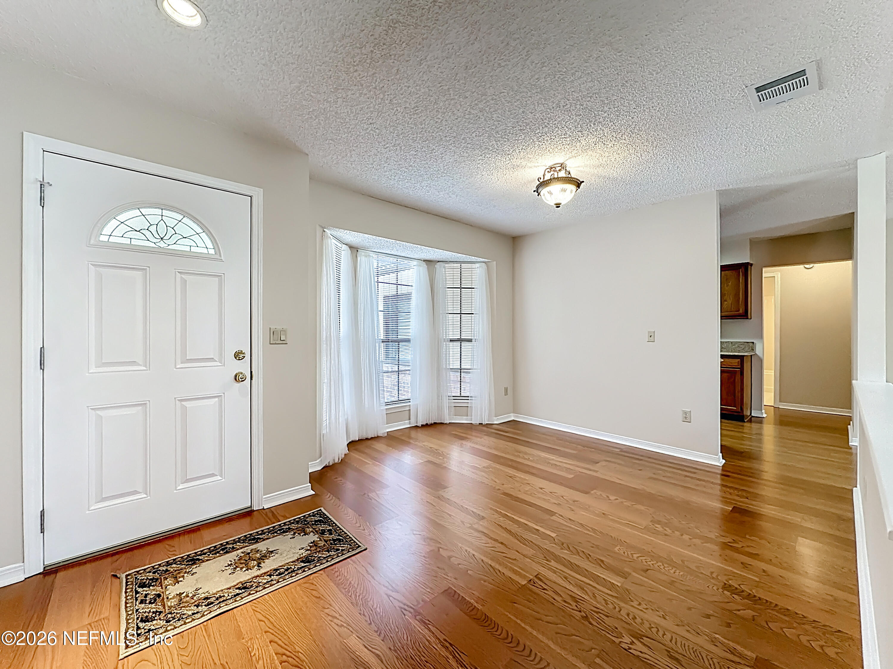10298 Lone Star Road Jacksonville, FL 32225 - Photo 4 of 42 wooden floor in an empty room with a window