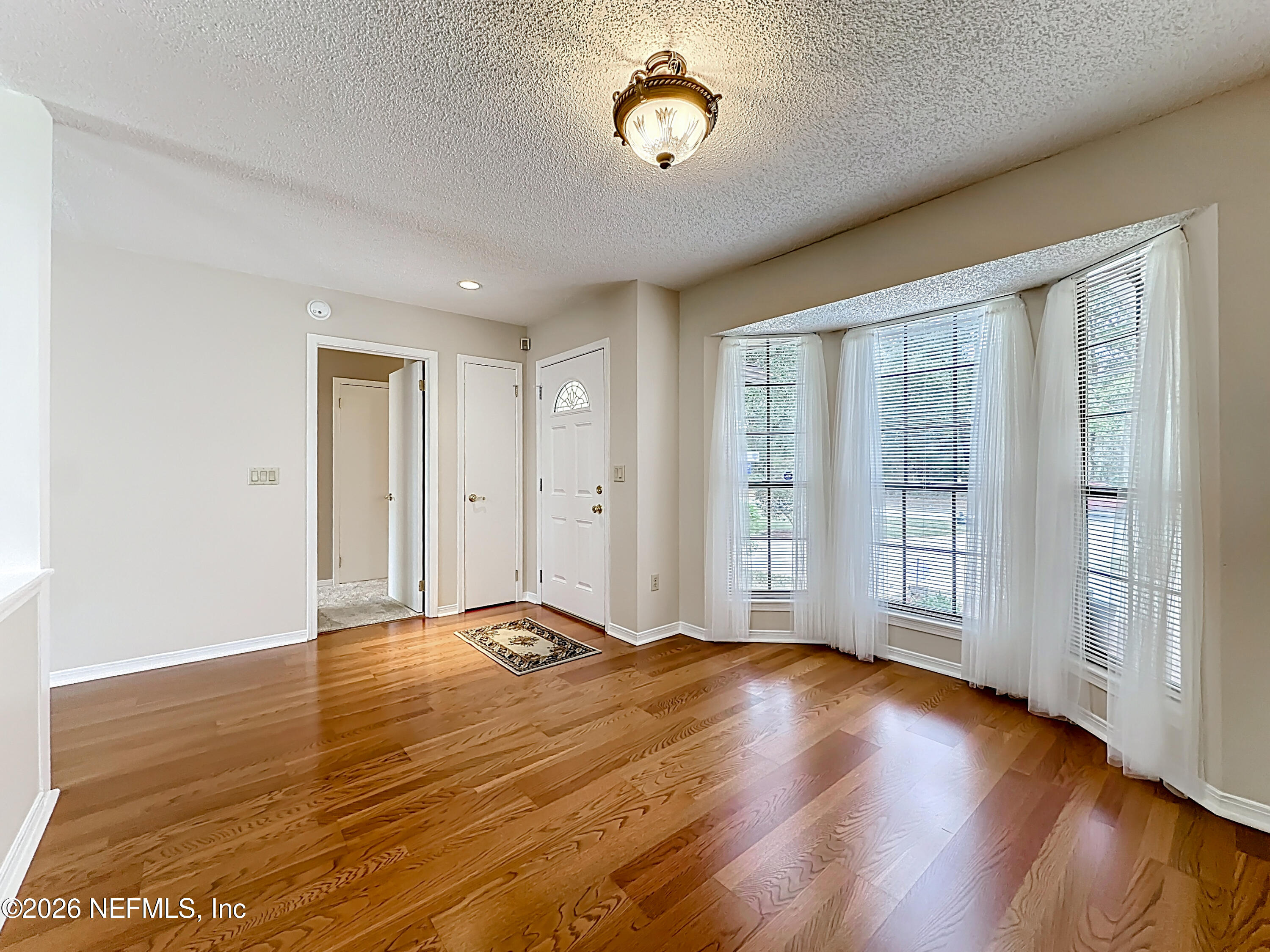 10298 Lone Star Road Jacksonville, FL 32225 - Photo 5 of 42 a view of an empty room with wooden floor and a window