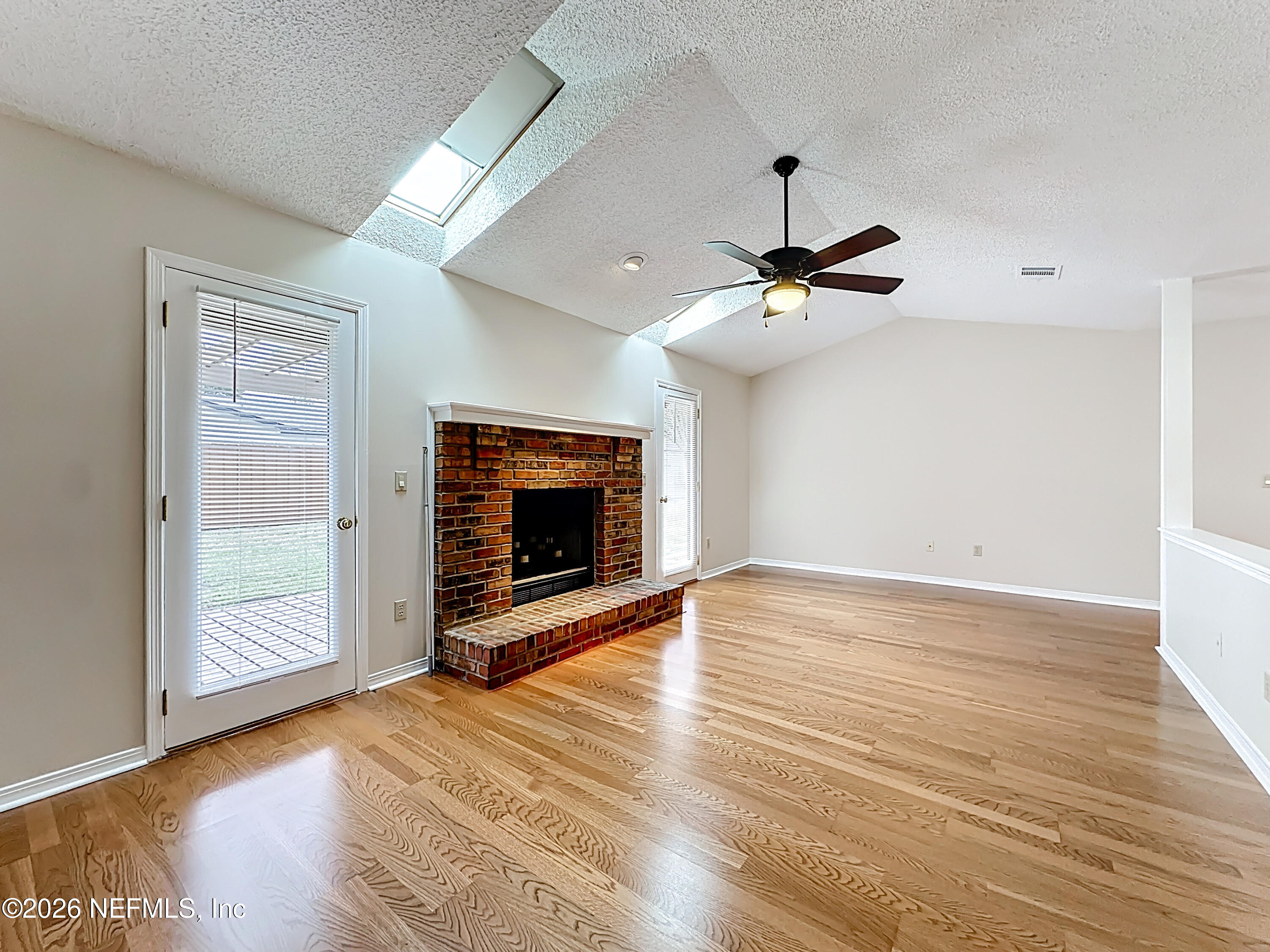 10298 Lone Star Road Jacksonville, FL 32225 - Photo 9 of 42 a view of an empty room with wooden floor and a fireplace