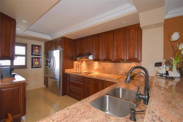a kitchen with stainless steel appliances granite countertop a refrigerator and a sink