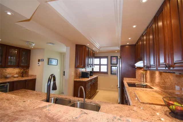 a kitchen with stainless steel appliances granite countertop a refrigerator and a sink