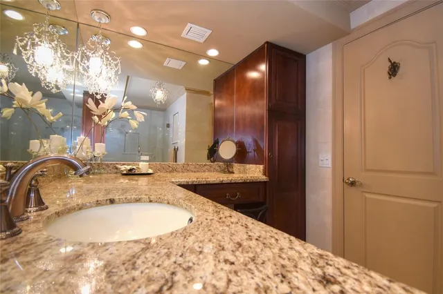 a bedroom with a bed and a lamp on dresser