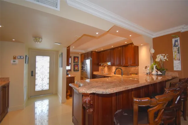 a kitchen with stainless steel appliances kitchen island granite countertop a refrigerator and stove