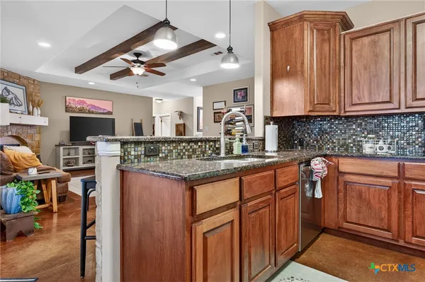 a kitchen with stainless steel appliances granite countertop a sink stove and cabinets