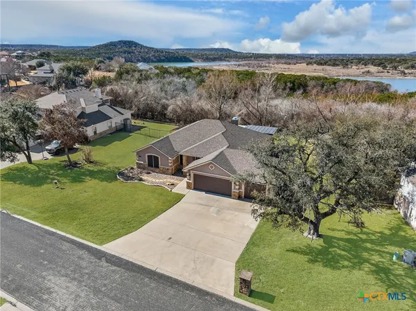 an aerial view of a house with a yard and lake view