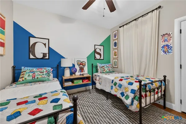 a bedroom with a bed a window and painting on the wall