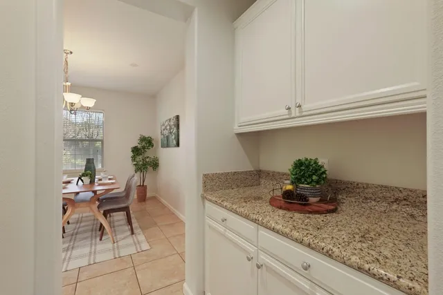 a kitchen with granite countertop cabinets and chair