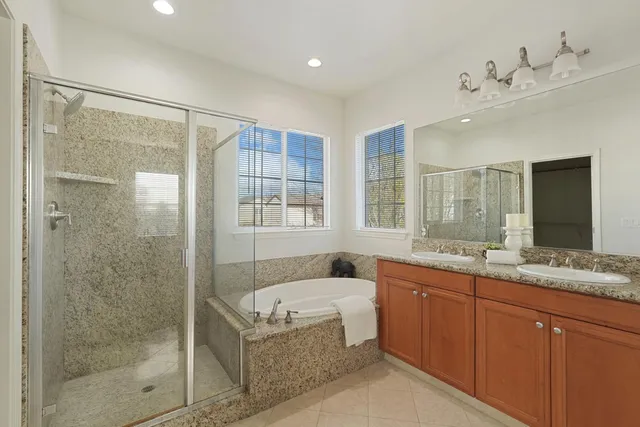 a bathroom with a granite countertop sink a mirror and a bathtub