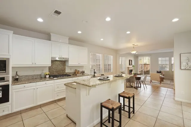 a kitchen with appliances a sink a counter top space and living room view
