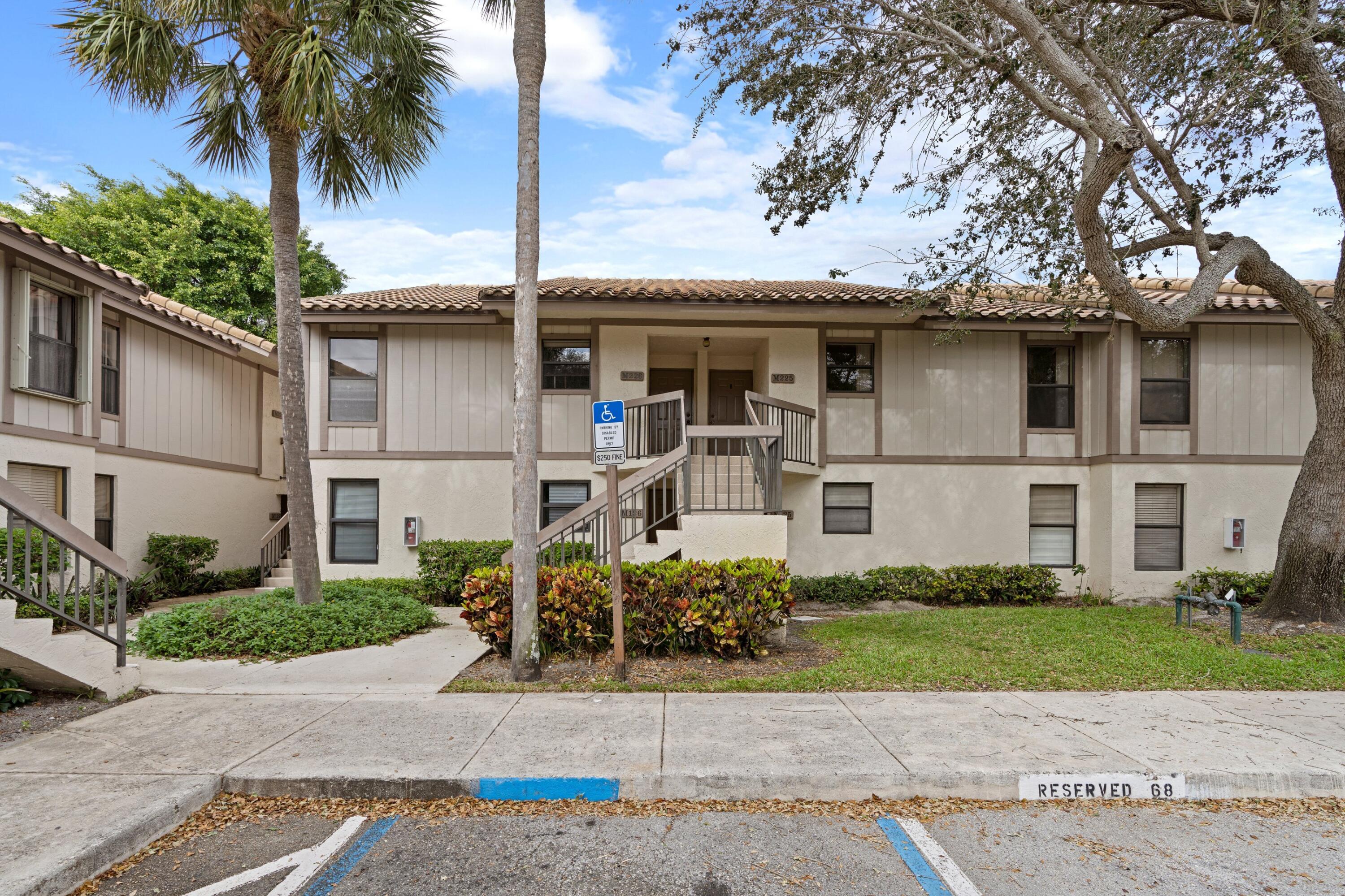 3139 Millwood Terrace, Unit 2250 Boca Raton, FL 33431 - Photo 2 of 25 a front view of a house with a garden