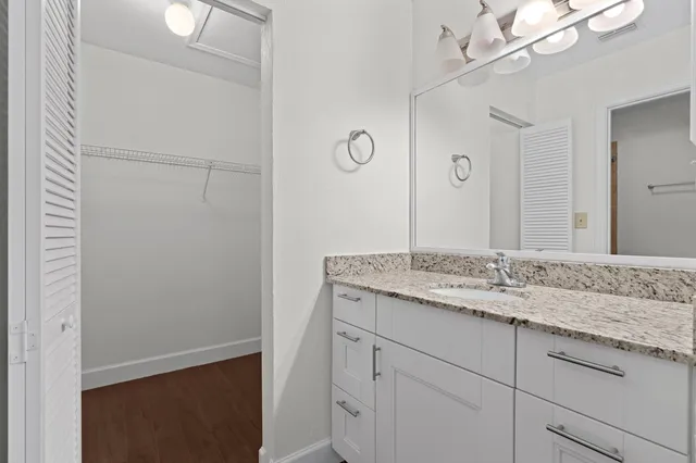a bathroom with a granite countertop sink and a mirror