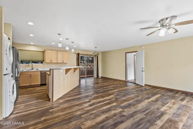 a large white kitchen with kitchen island a sink stainless steel appliances and cabinets