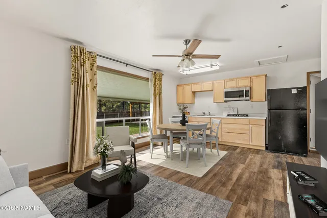 a living room with furniture a fireplace and a dining table with wooden floor