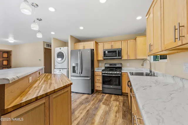 a kitchen with stainless steel appliances granite countertop a refrigerator a stove top oven a sink and dishwasher