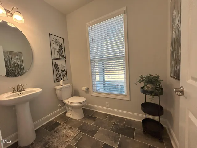 a bathroom with a toilet sink and window