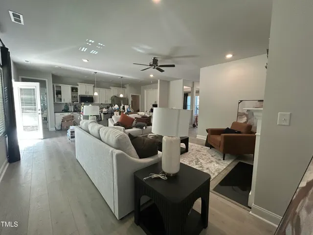 an empty room with wooden floor fireplace and windows
