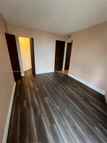 a view of a room with wooden floor