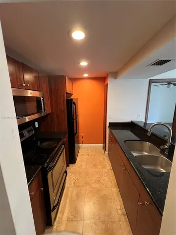 a kitchen with granite countertop sink stainless steel appliances and cabinets