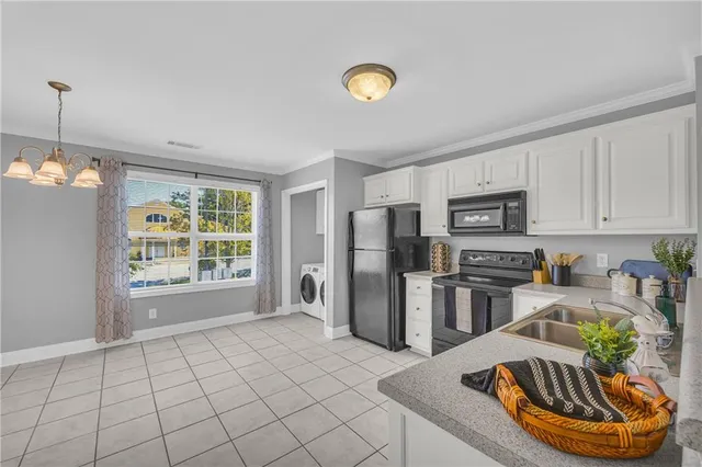 a kitchen with stainless steel appliances granite countertop a sink dishwasher a refrigerator microwave and white countertops with wooden floor