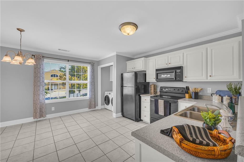 105 Whitehead Road, Unit 17 Athens, GA 30606 - Photo 11 of 38 a kitchen with stainless steel appliances granite countertop a sink dishwasher a refrigerator microwave and white countertops with wooden floor