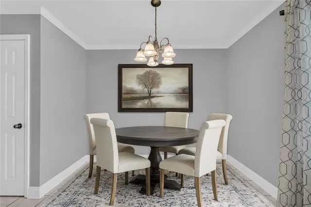 a view of an empty room with chandelier fan