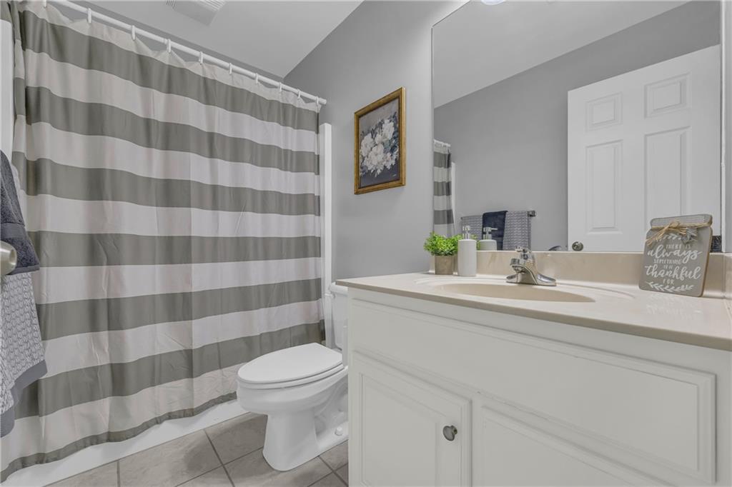 105 Whitehead Road, Unit 17 Athens, GA 30606 - Photo 27 of 38 a bathroom with a sink a toilet a mirror and shower curtain