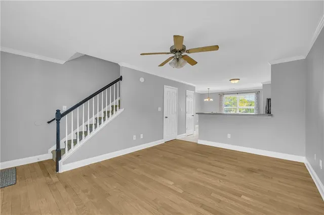 a view of room with a ceiling fan and wooden floor