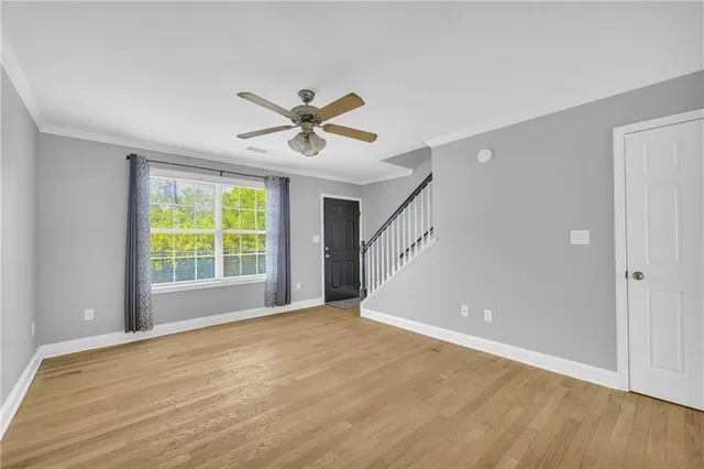 a view of a big room with wooden floor and windows