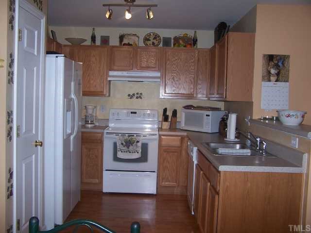 5816 Bryanstone Place Raleigh, NC 27610 - Photo 3 of 8 a kitchen with stainless steel appliances granite countertop a sink a stove a refrigerator and cabinets